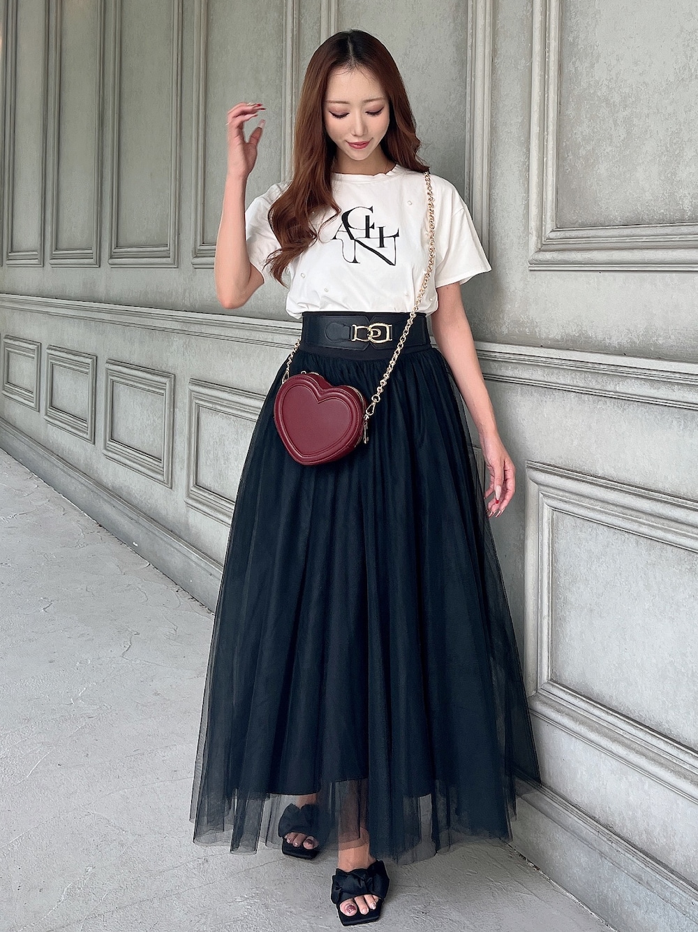 ホワイト系のTシャツ/カットソー、ブラック系のスカート、レッド系のショルダーバッグを着用したレディースの夏コーディネートの1枚目の写真