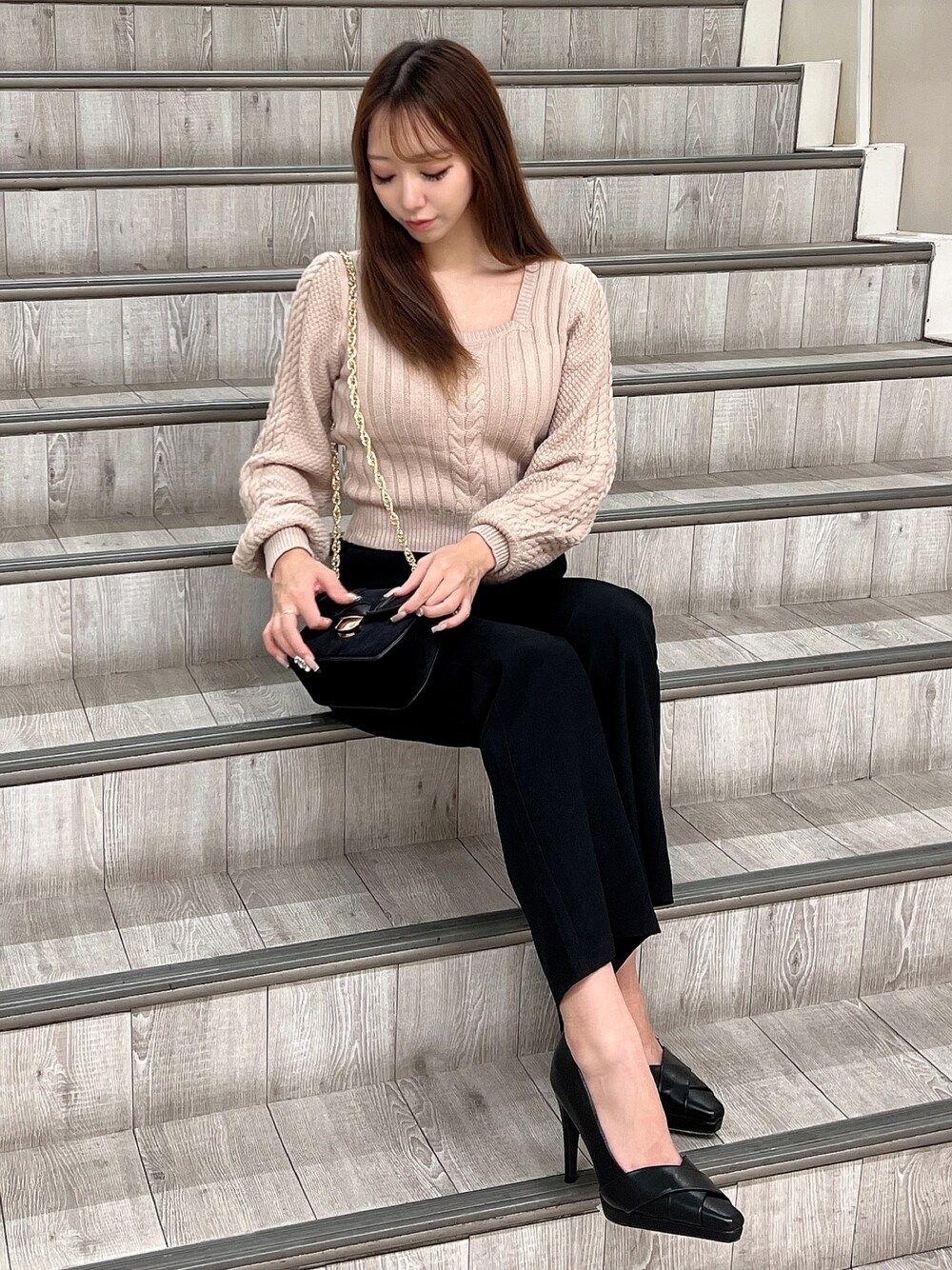 ブラック系のその他パンツ、ブラック系のショルダーバッグ、ベージュ系のニット/セーターを着用したレディースの秋コーディネートの1枚目の写真