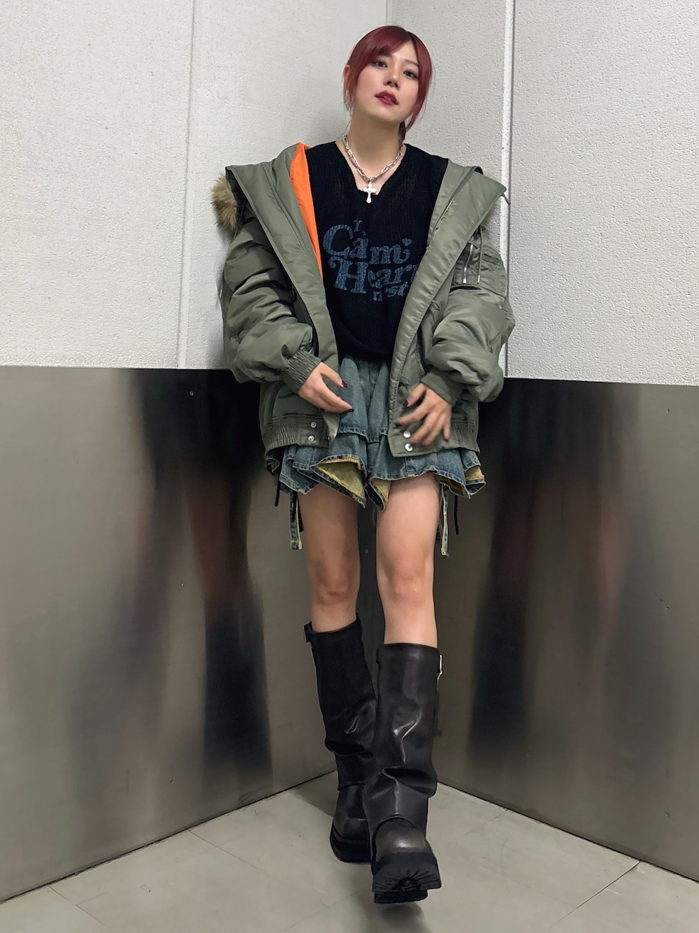 ブルー系のデニムスカート、ブラック系のブーツ、ブラック系のニット/セーターを着用したレディースの秋コーディネートの1枚目の写真