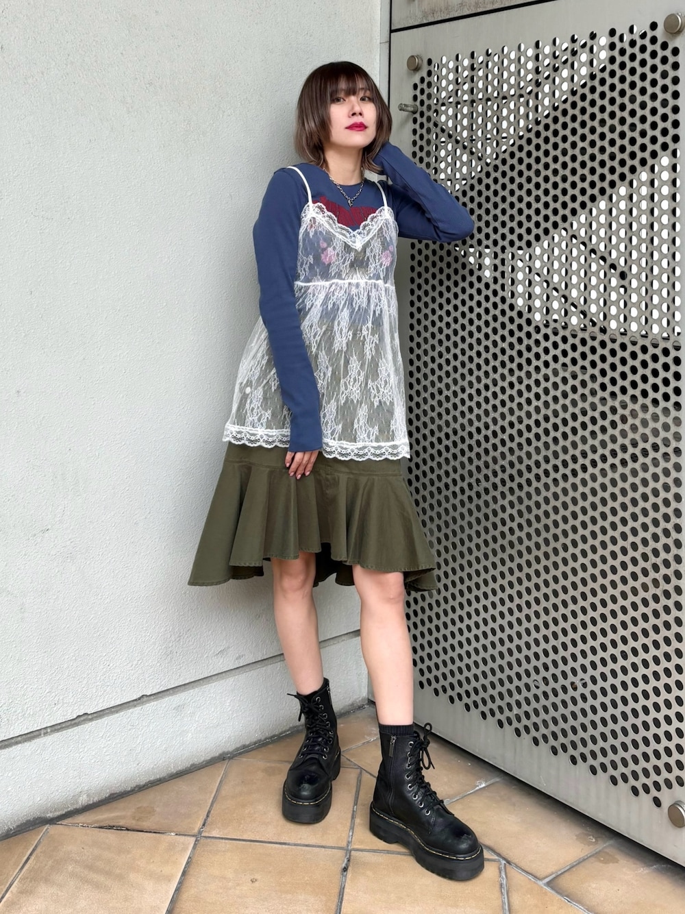 グリーン系のスカート、ブルー系のTシャツ/カットソー、ホワイト系のキャミソールを着用したレディースの冬コーディネートの1枚目の写真