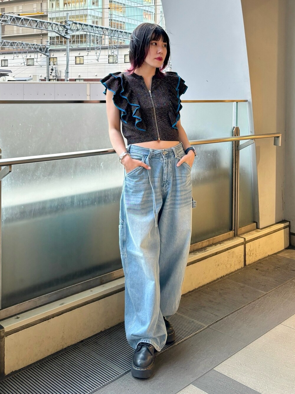 ブルー系のデニムパンツ、ブラック系のニット/セーター、シルバー系のブレスレットを着用したレディースの夏コーディネートの1枚目の写真