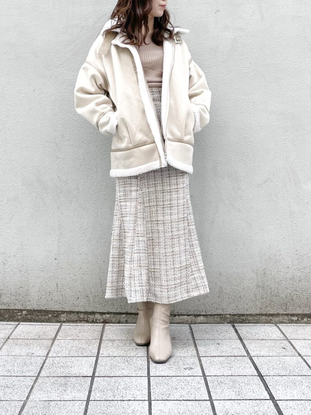 ホワイト系のブルゾン、ベージュ系のブーツ、ベージュ系のニット/セーターを着用したレディースの冬コーディネートの1枚目の写真