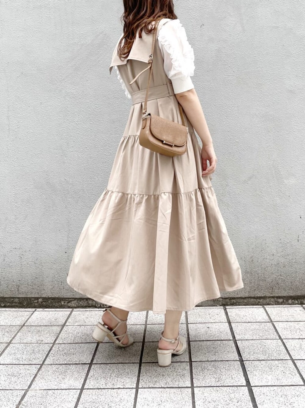 ベージュ系のワンピース、ホワイト系のパンプス、ブラウン系のショルダーバッグを着用したレディースの春コーディネートの1枚目の写真