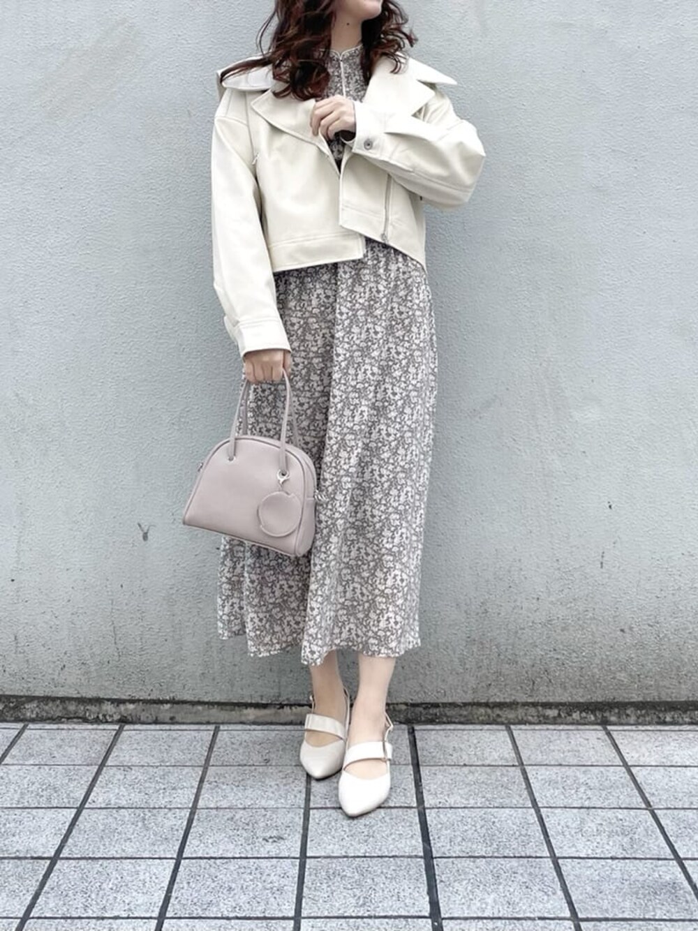 ホワイト系のワンピース、ホワイト系のライダースジャケット、ホワイト系のパンプスを着用したレディースの冬コーディネートの1枚目の写真