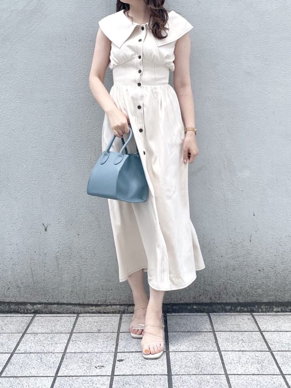 パープル系のサンダル、ブルー系のハンドバッグ、ホワイト系のワンピースを着用したレディースの夏コーディネートの1枚目の写真