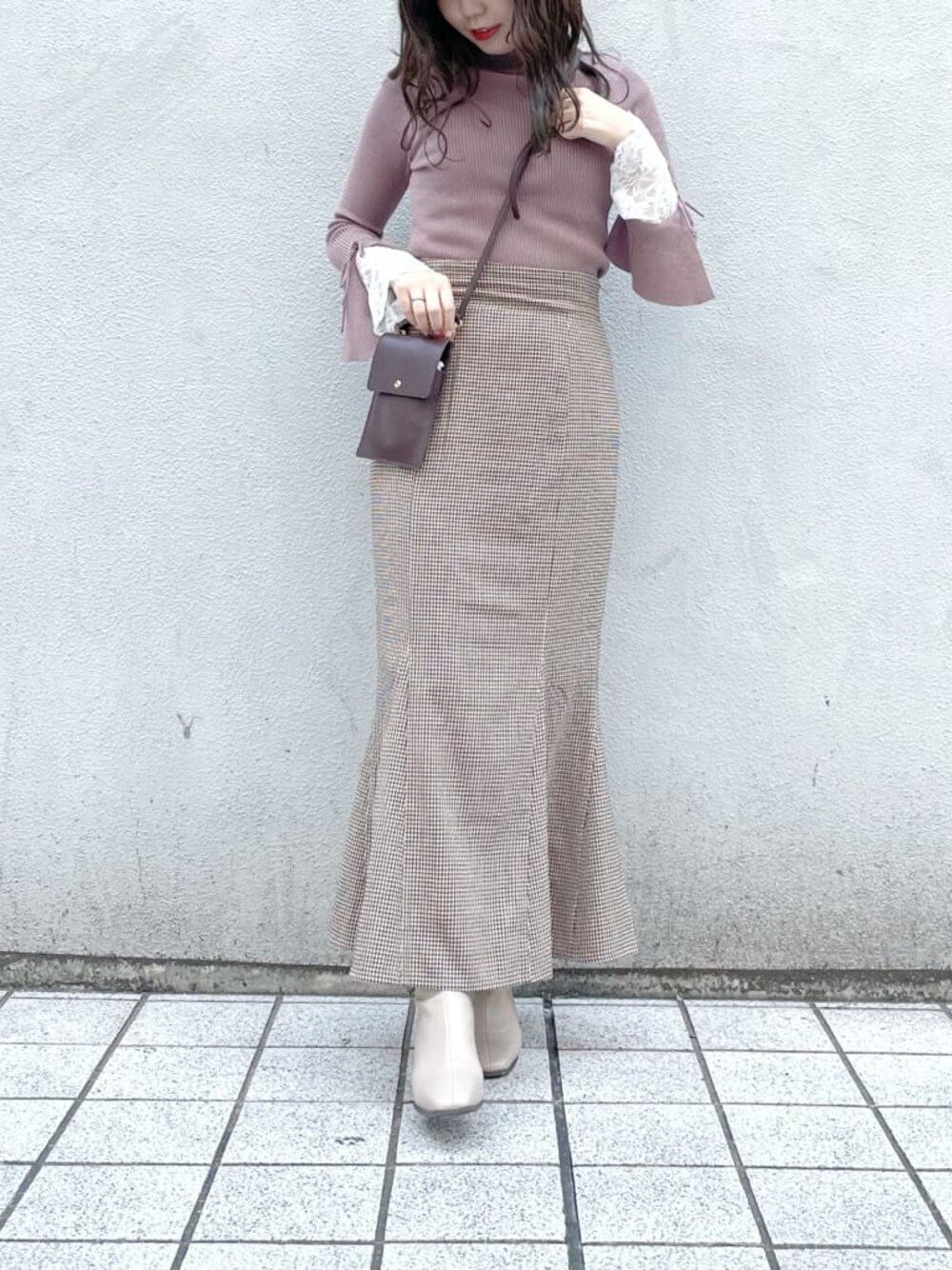 ブラウン系のスカート、ベージュ系のブーツ、ピンク系のニット/セーターを着用したレディースの秋コーディネートの1枚目の写真