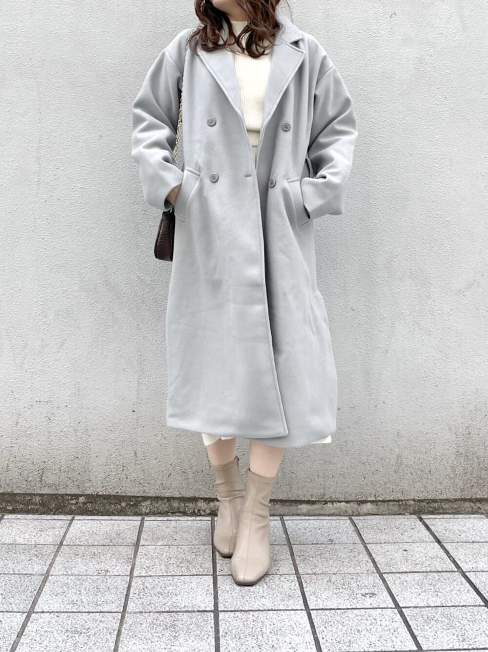 ベージュ系のブーツ、ホワイト系のワンピース、ブルー系のチェスターコートを着用したレディースの冬コーディネートの1枚目の写真