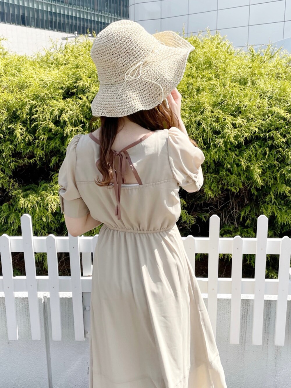 ベージュ系のワンピース、その他のサンダル、ホワイト系のハットを着用したレディースの春コーディネートの1枚目の写真