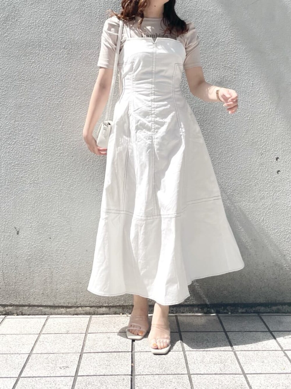 パープル系のサンダル、ホワイト系のショルダーバッグ、ホワイト系のワンピースを着用したレディースの春コーディネートの1枚目の写真