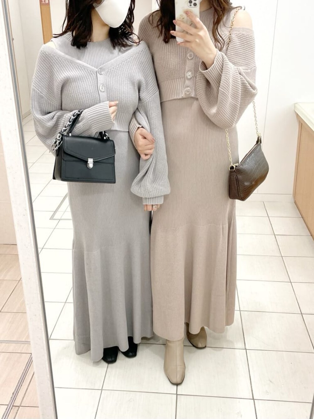 ブラック系のブーツ、ベージュ系のブーツ、ブラック系のハンドバッグを着用したレディースの冬コーディネートの1枚目の写真