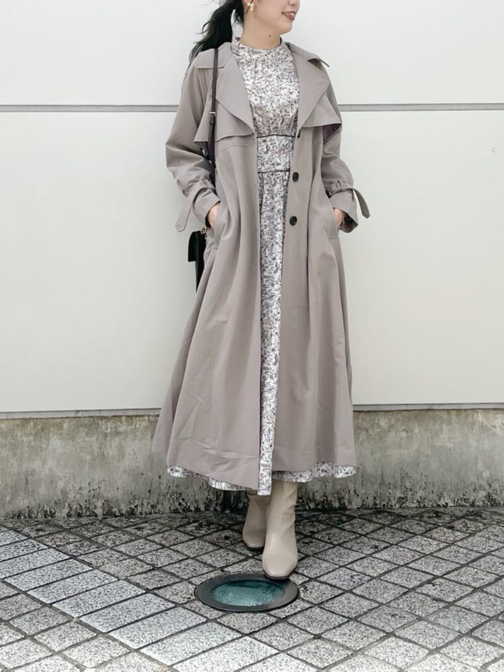 ブラウン系のワンピース、グレー系のトレンチコート、ベージュ系のブーツを着用したレディースの秋コーディネートの1枚目の写真