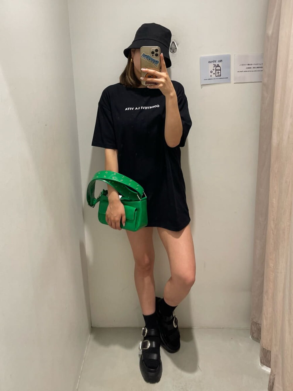 グリーン系のショルダーバッグ、ブラック系のサンダル、ブラック系のTシャツ/カットソーを着用したレディースの春コーディネートの1枚目の写真
