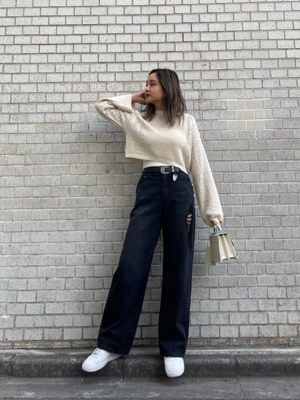 ホワイト系のキャミソール、ブラック系のデニムパンツ、ホワイト系のニット/セーターを着用したレディースの春コーディネートの1枚目の写真