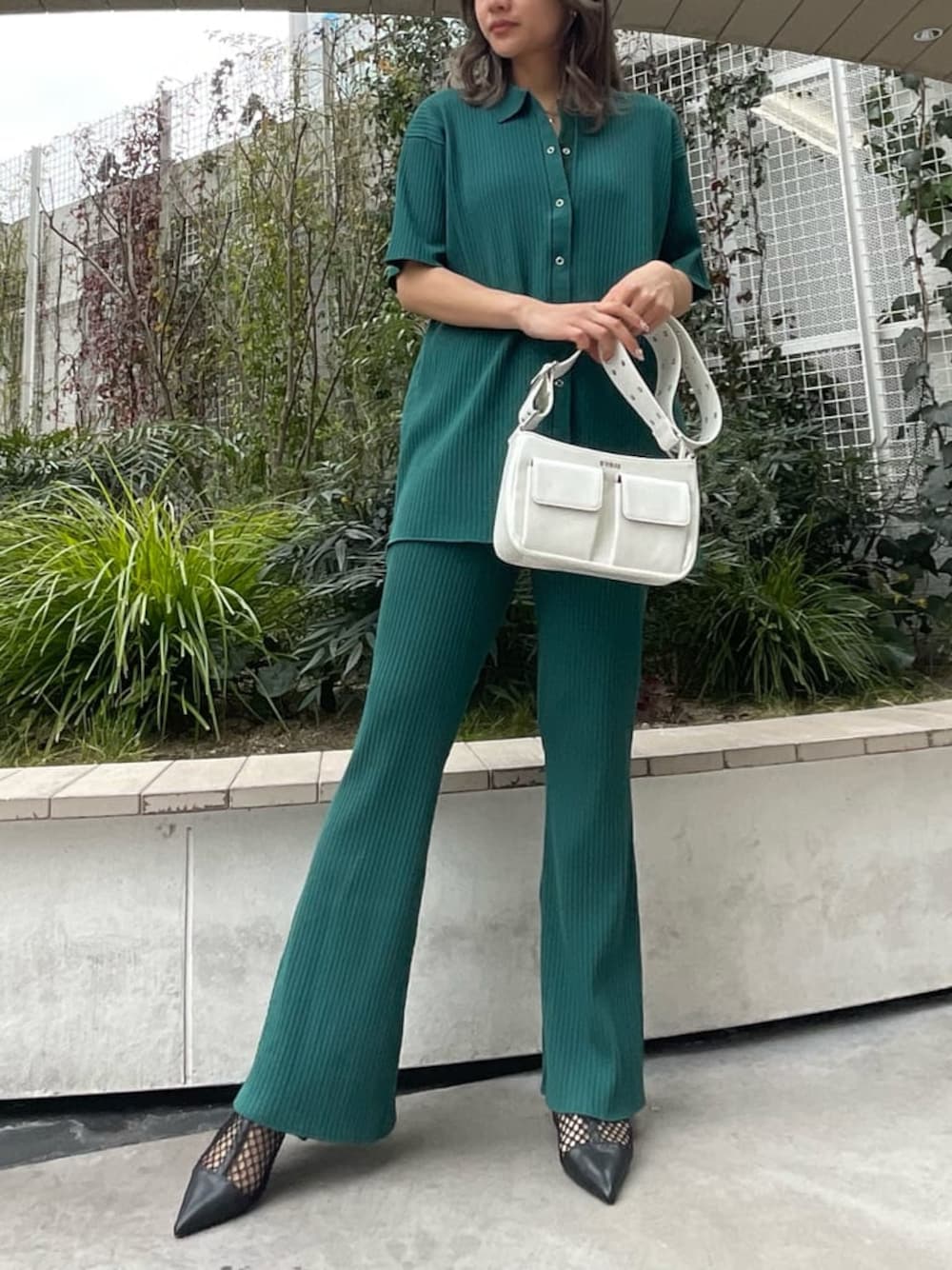 ブラック系のパンプス、ホワイト系のショルダーバッグ、グリーン系のその他パンツを着用したレディースの春コーディネートの1枚目の写真