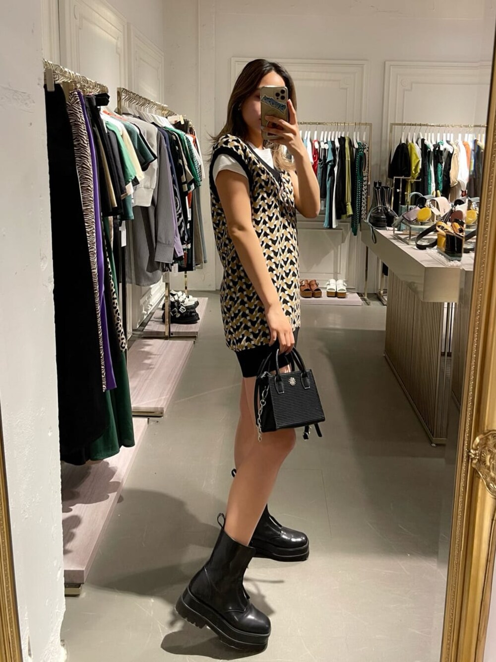 ブラック系のブーツ、ベージュ系のデニムパンツ、ブラック系のニット/セーターを着用したレディースの春コーディネートの1枚目の写真