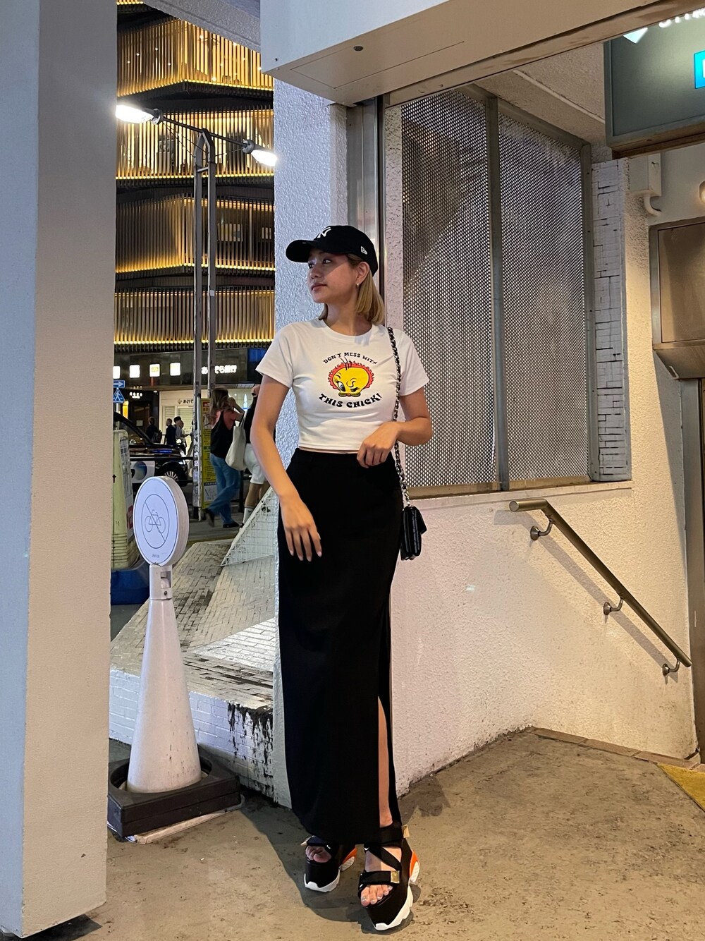 ホワイト系のTシャツ/カットソー、ブラック系のスカート、ブラック系のショルダーバッグを着用したレディースの夏コーディネートの1枚目の写真