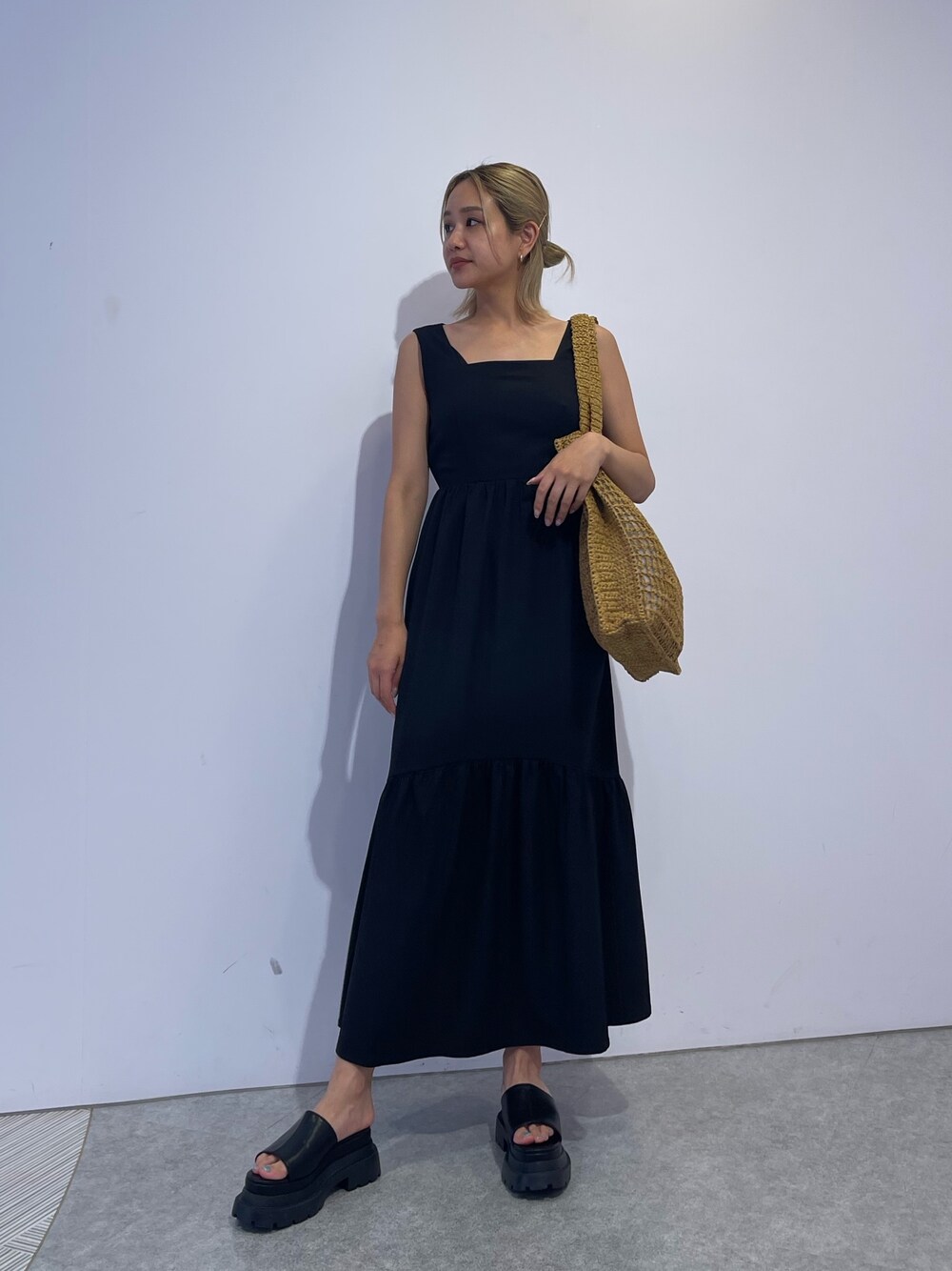 ベージュ系のトートバッグ、ブラック系のワンピース、ブラック系のサンダルを着用したレディースの夏コーディネートの1枚目の写真