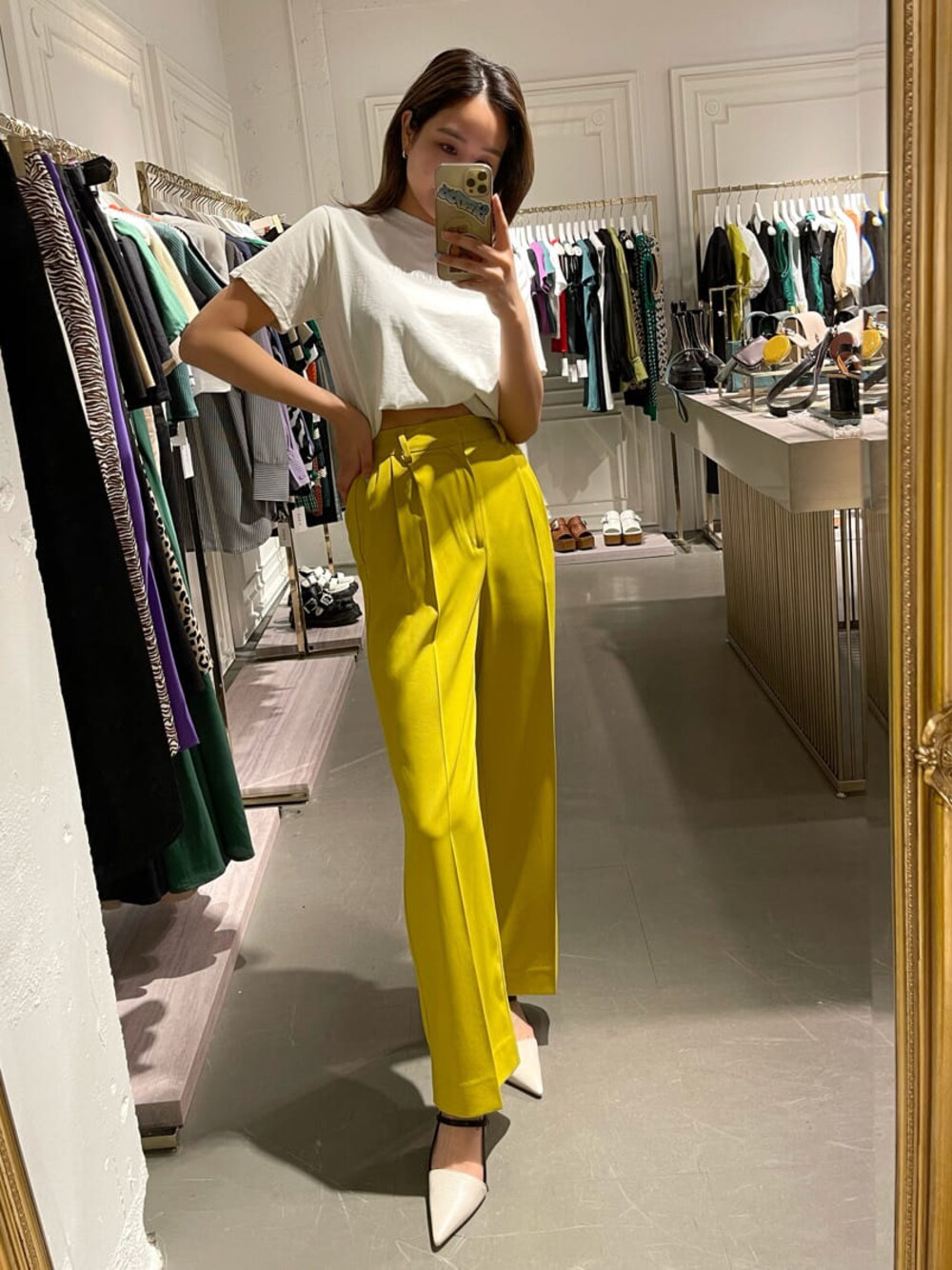 イエロー系のスラックス、ホワイト系のTシャツ/カットソー、ホワイト系のサンダルを着用したレディースの春コーディネートの1枚目の写真