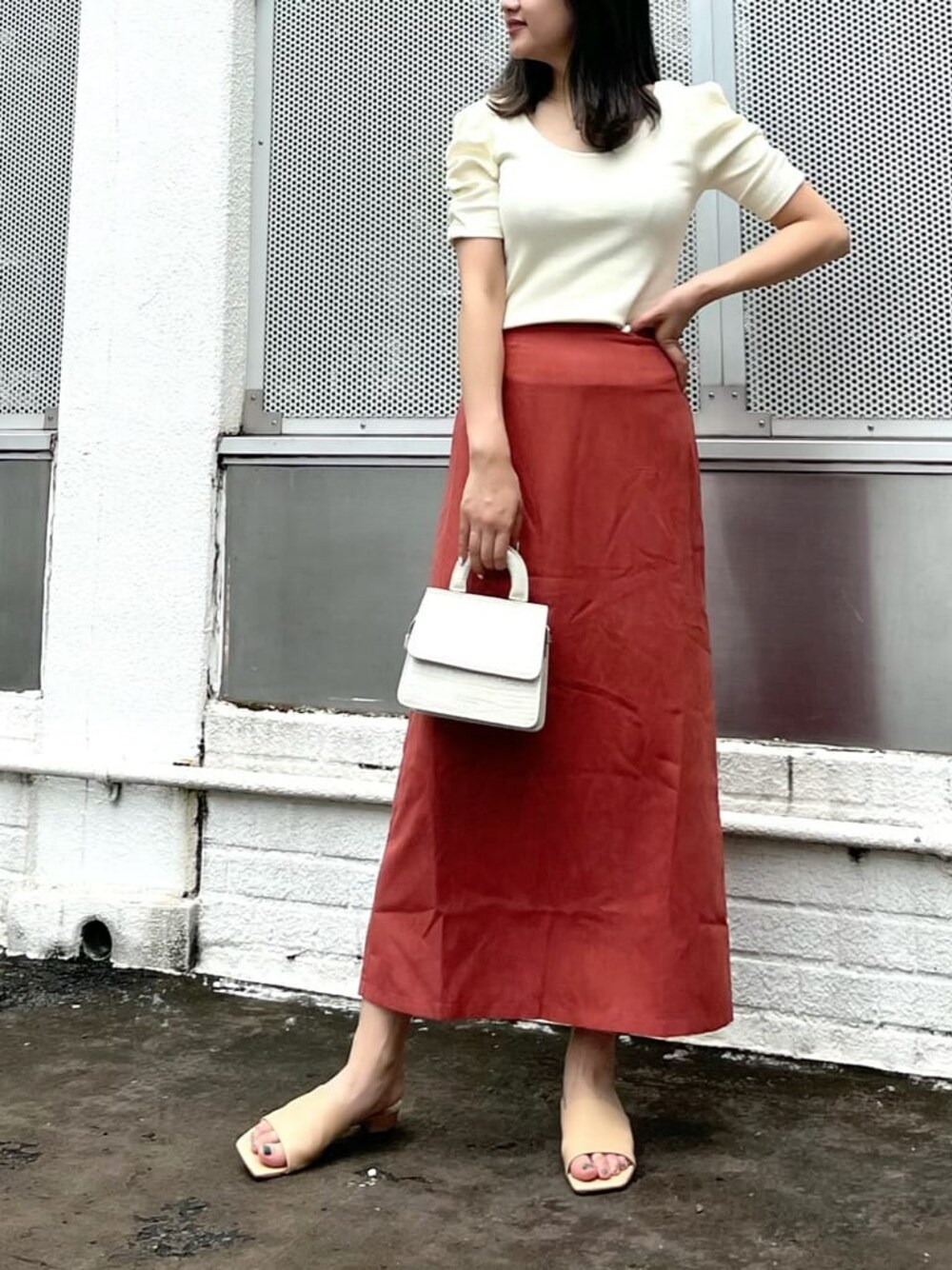 オレンジ系のスカート、ホワイト系のTシャツ/カットソーを着用したレディースの夏コーディネートの1枚目の写真
