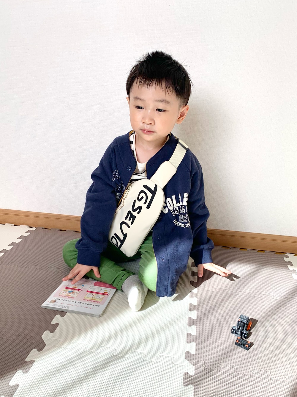 ベージュ系のボディバッグ/ウエストポーチ、ブルー系のカーディガン/ボレロ、グリーン系のその他パンツを着用したキッズの春コーディネートの1枚目の写真