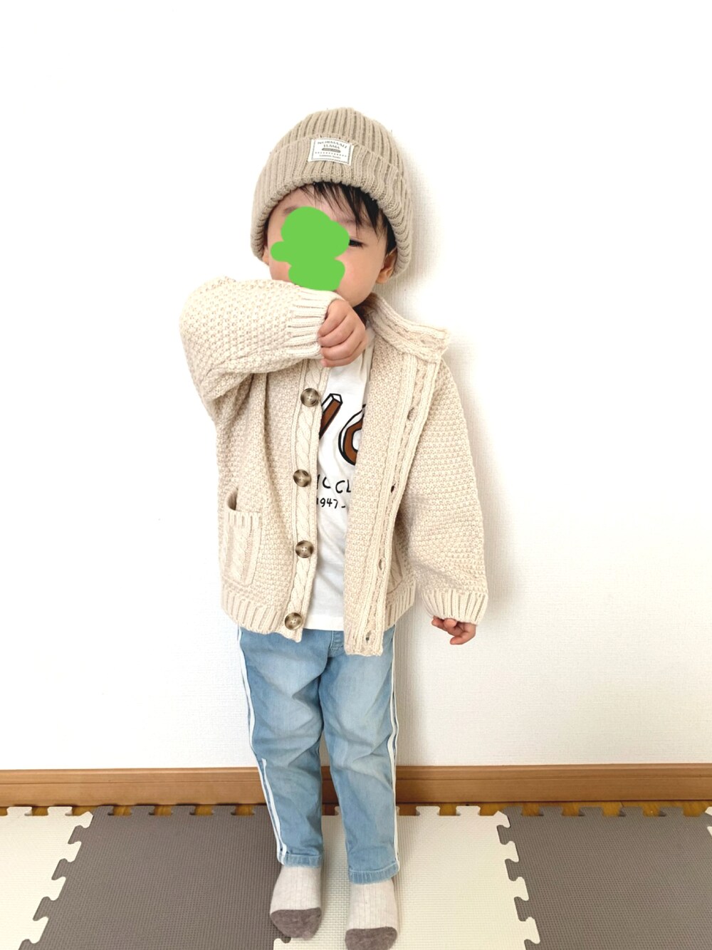 ベージュ系のカーディガン/ボレロ、ブルー系のデニムパンツ、ホワイト系のTシャツ/カットソーを着用したキッズの秋コーディネートの1枚目の写真