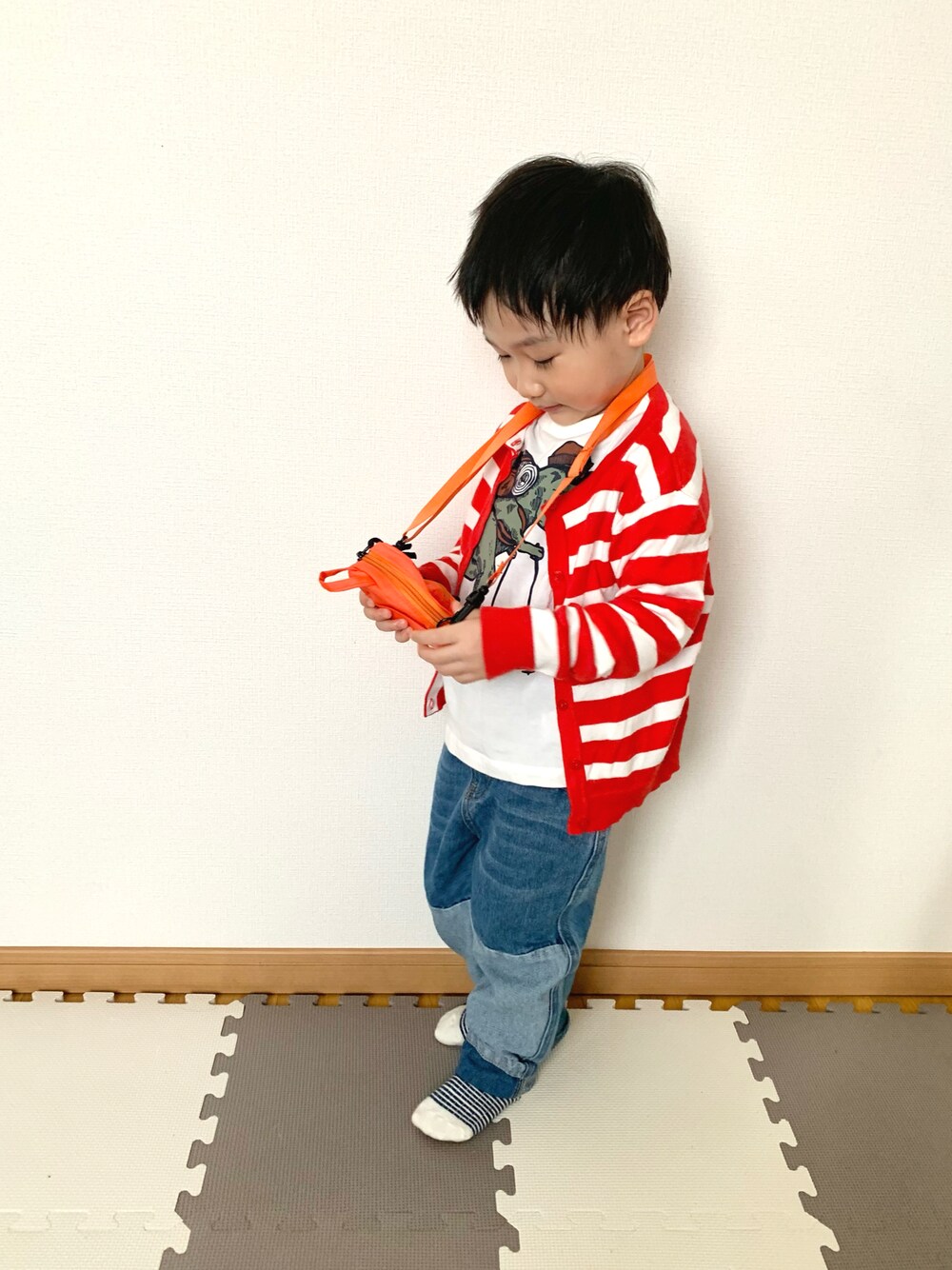 ホワイト系のTシャツ/カットソー、ブルー系のデニムパンツ、レッド系のカーディガン/ボレロを着用したキッズの春コーディネートの1枚目の写真