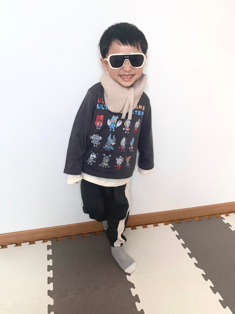 グレー系のスウェット、グレー系のスウェットパンツ、ベージュ系のTシャツ/カットソーを着用したキッズの冬コーディネートの1枚目の写真