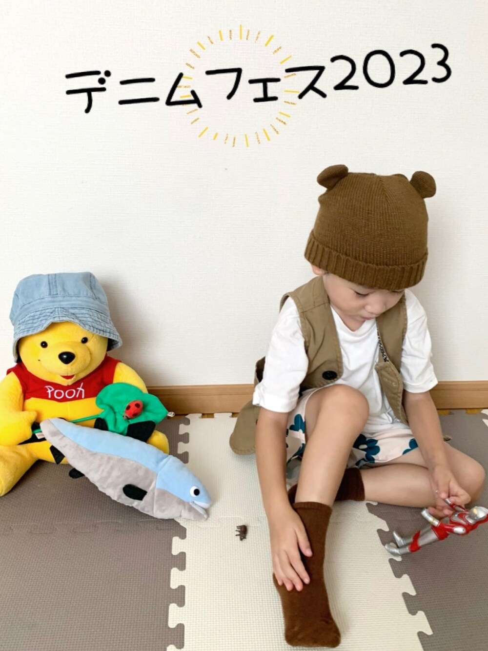 ブラウン系のベスト、ホワイト系のパンツ、ブラウン系のニットキャップ/ビーニーを着用したキッズの秋コーディネートの1枚目の写真