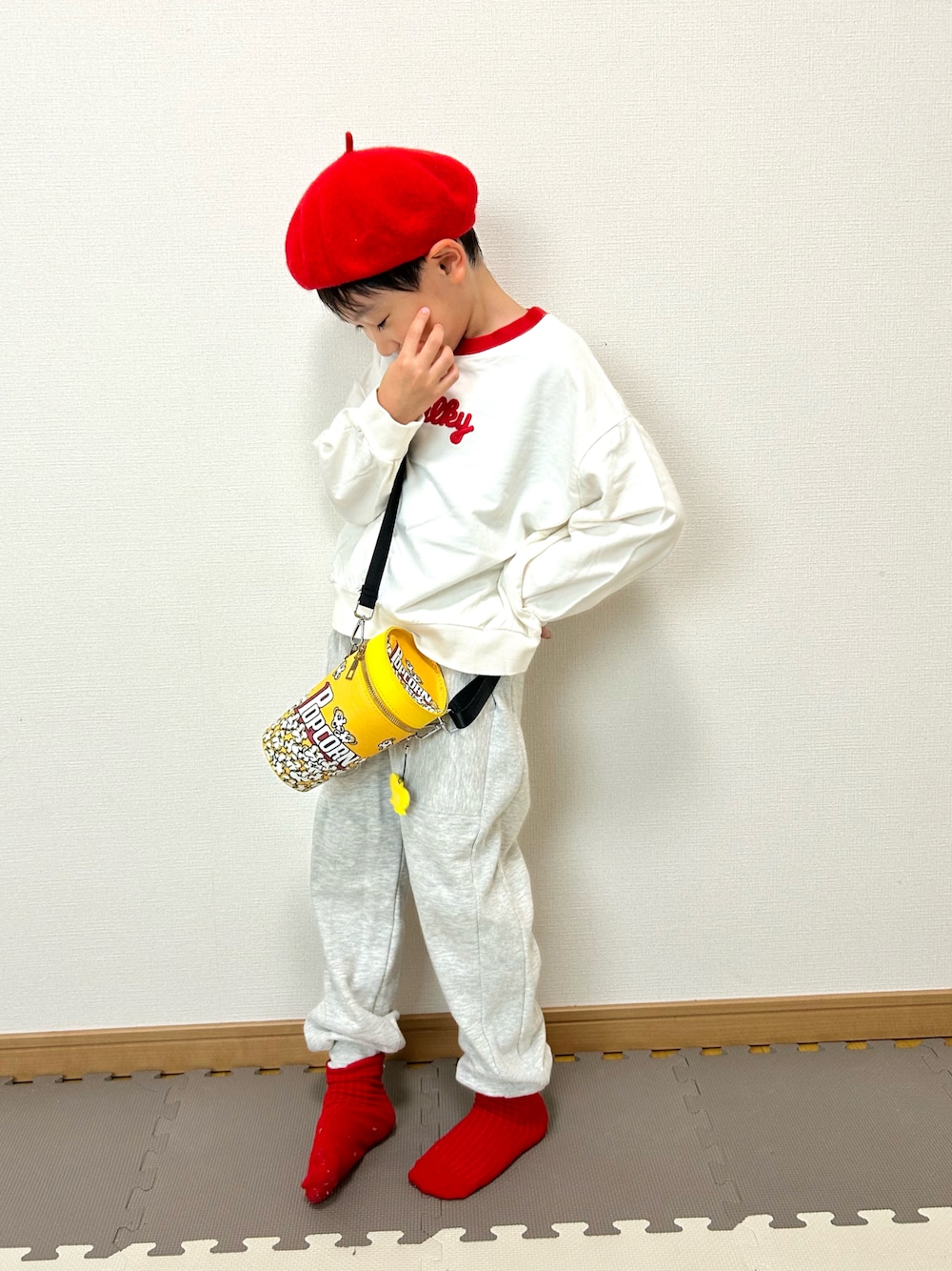 グレー系のスウェットパンツ、ホワイト系のスウェット、イエロー系のショルダーバッグを着用したキッズの秋コーディネートの1枚目の写真