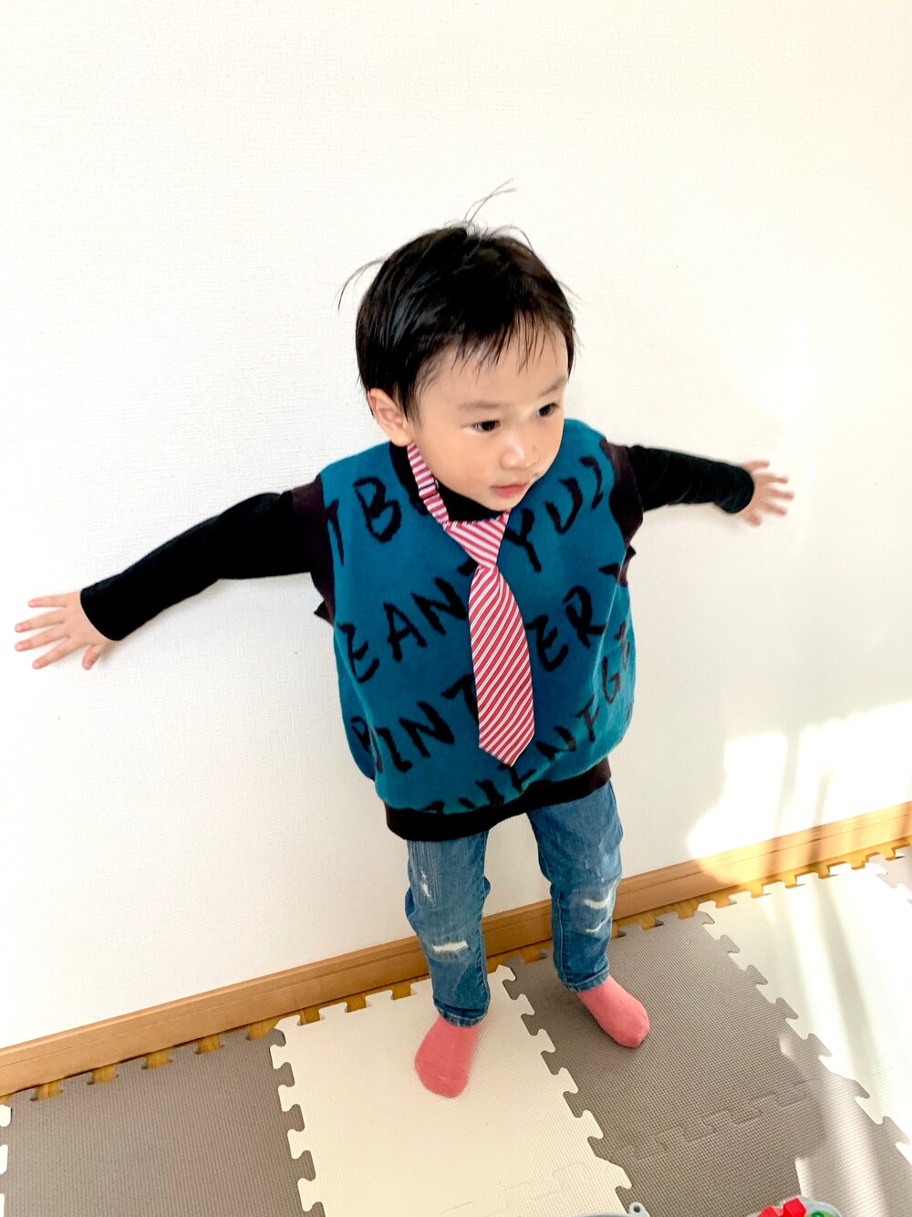 ブルー系のベスト、ブルー系のデニムパンツ、ブラック系のTシャツ/カットソーを着用したキッズの春コーディネートの1枚目の写真