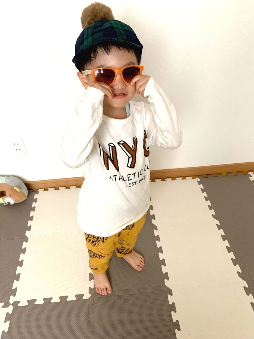 ホワイト系のTシャツ/カットソー、イエロー系のデニムパンツ、グリーン系のキャップを着用したキッズの秋コーディネートの1枚目の写真