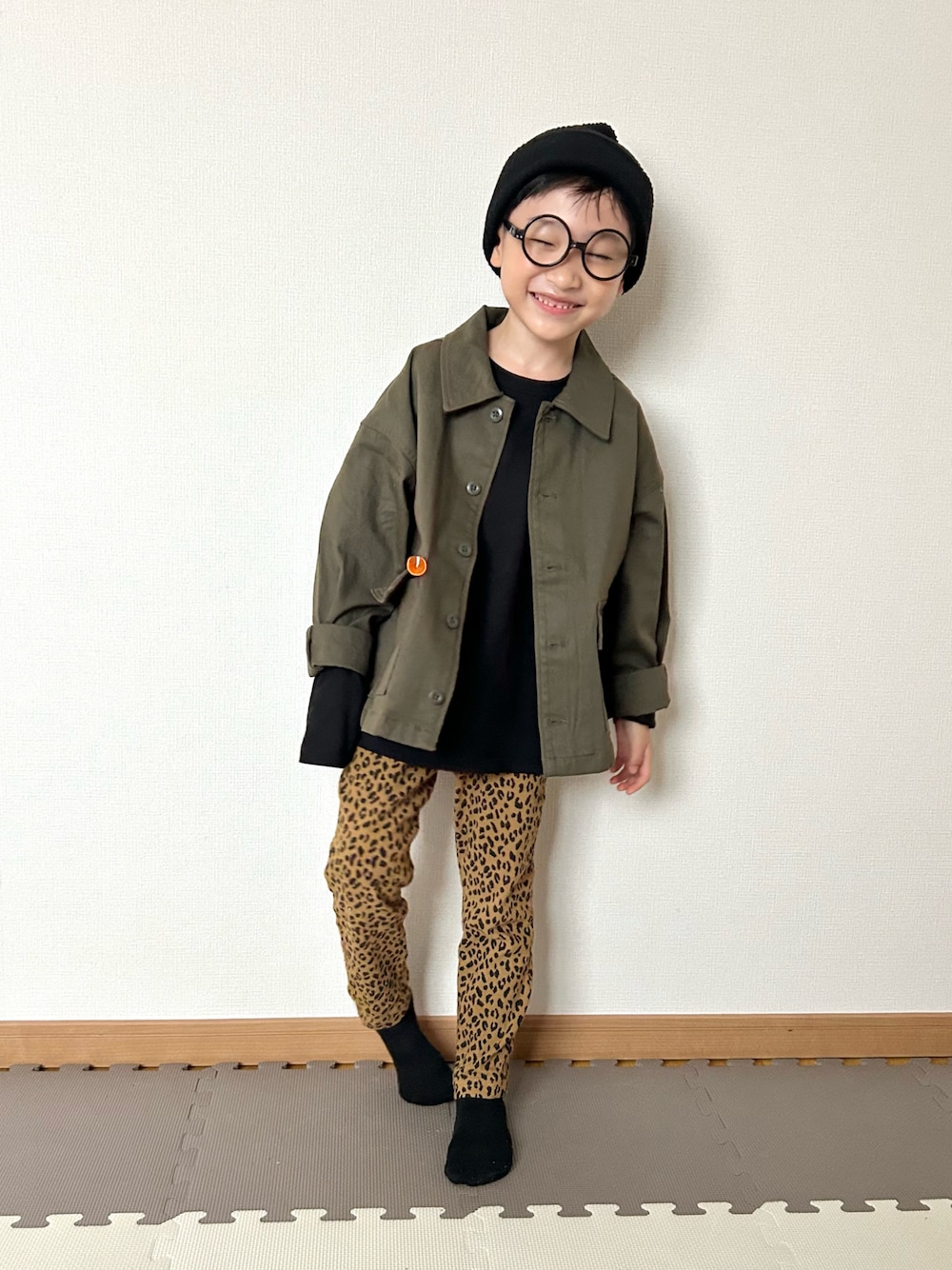 ブラック系のTシャツ/カットソー、グリーン系のジャケット/アウター、ブラウン系のパンツを着用したキッズの秋コーディネートの1枚目の写真