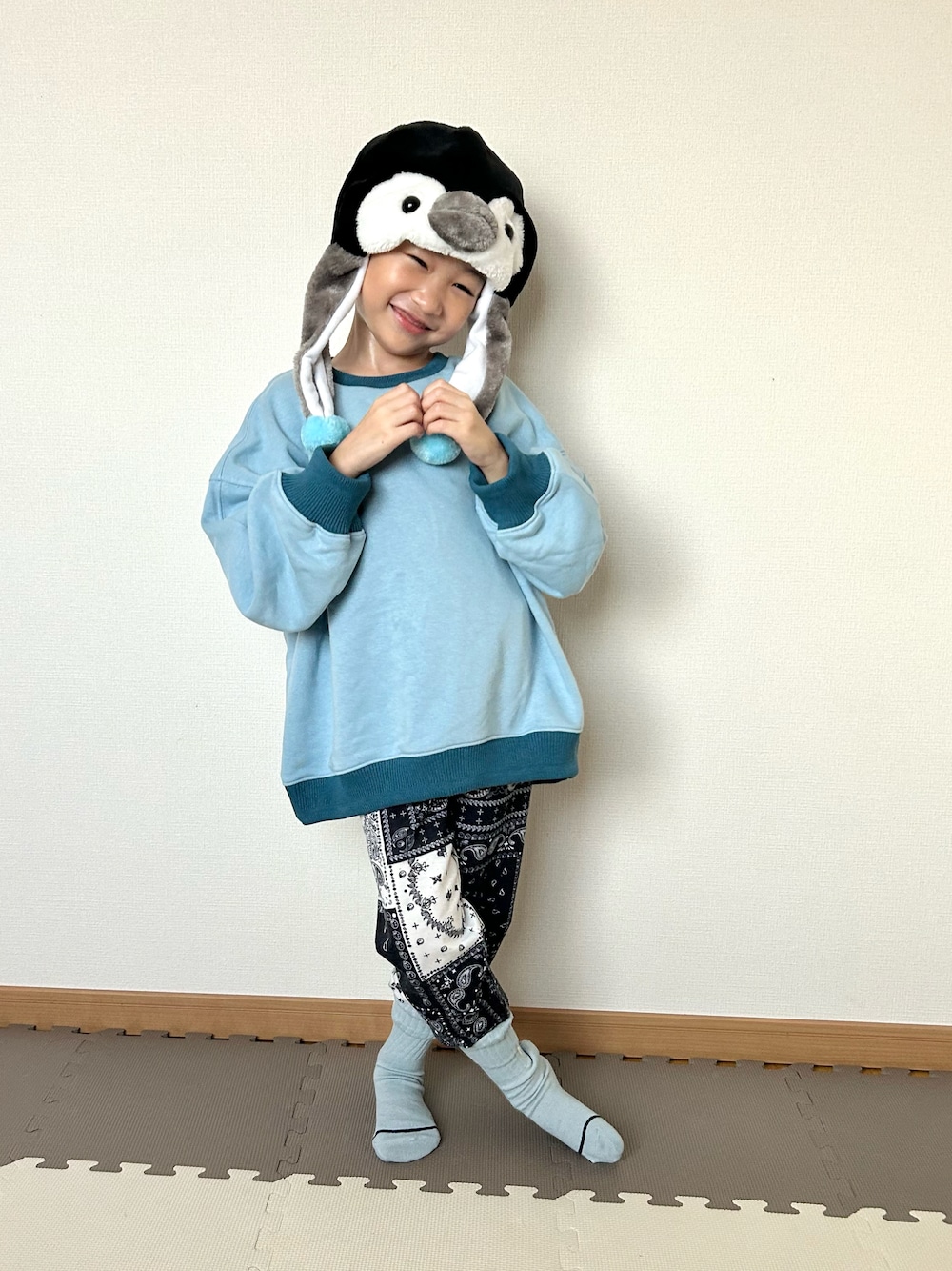 ブルー系のスウェット、ブルー系のスウェットパンツ、ブラック系の帽子を着用したキッズの秋コーディネートの1枚目の写真
