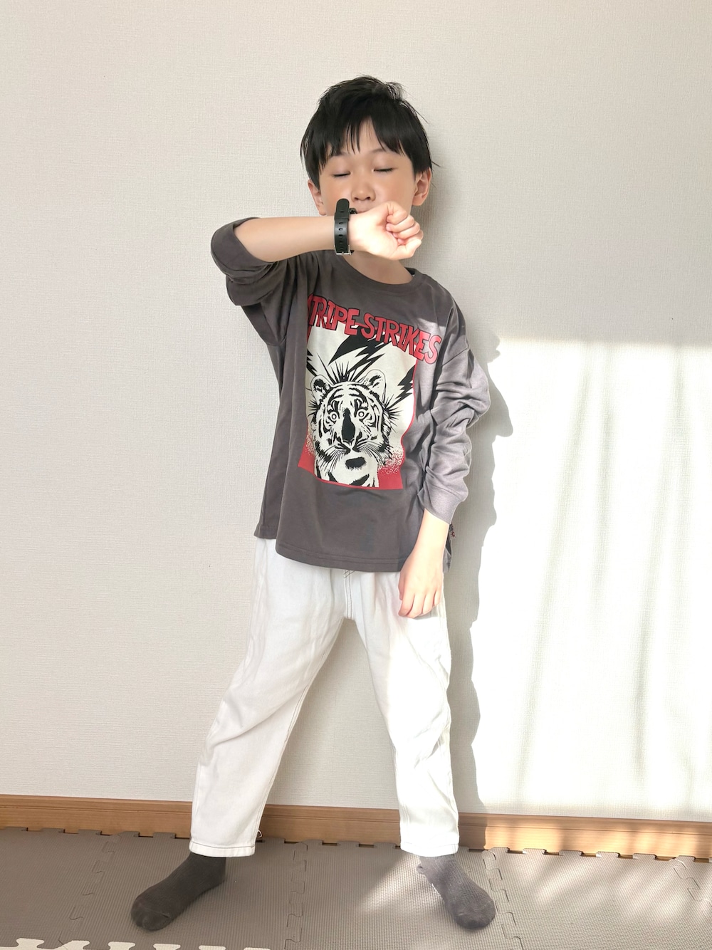 グレー系のTシャツ/カットソー、ホワイト系のデニムパンツ、ブラック系の腕時計を着用したキッズの春コーディネートの1枚目の写真