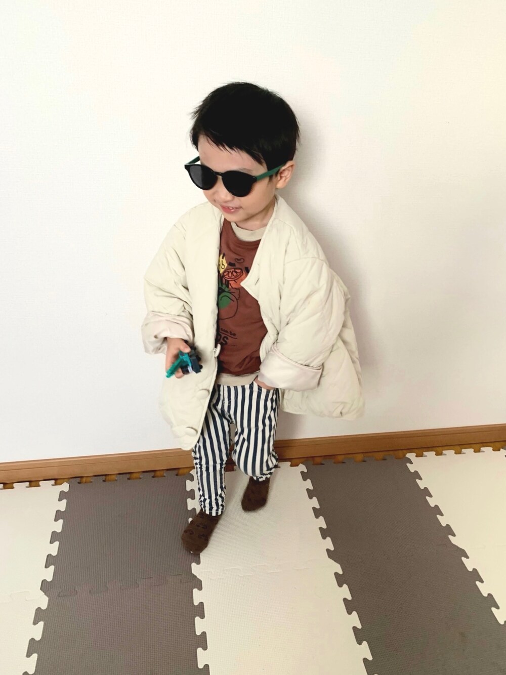 ブルー系のチノパンツ、ブラウン系のスウェット、ホワイト系のブルゾンを着用したキッズの冬コーディネートの1枚目の写真