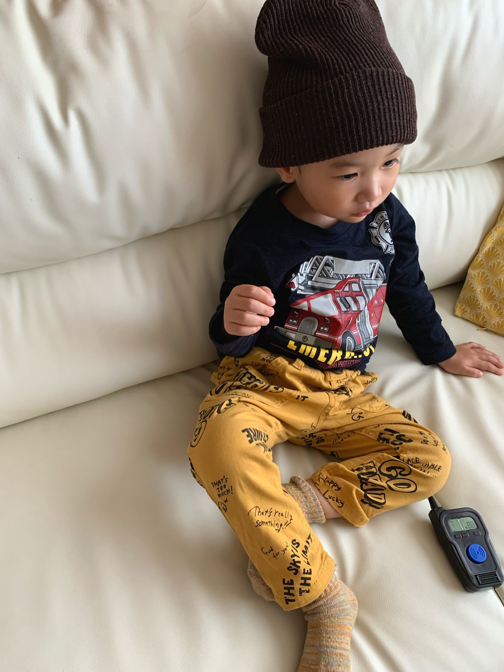 ブルー系のTシャツ/カットソー、イエロー系のチノパンツ、ブラウン系のニットキャップ/ビーニーを着用したキッズの秋コーディネートの1枚目の写真
