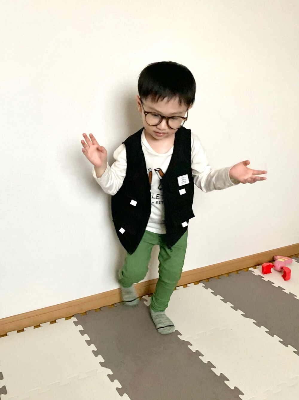 ブラック系のベスト、グリーン系のその他パンツ、ホワイト系のTシャツ/カットソーを着用したキッズの春コーディネートの1枚目の写真
