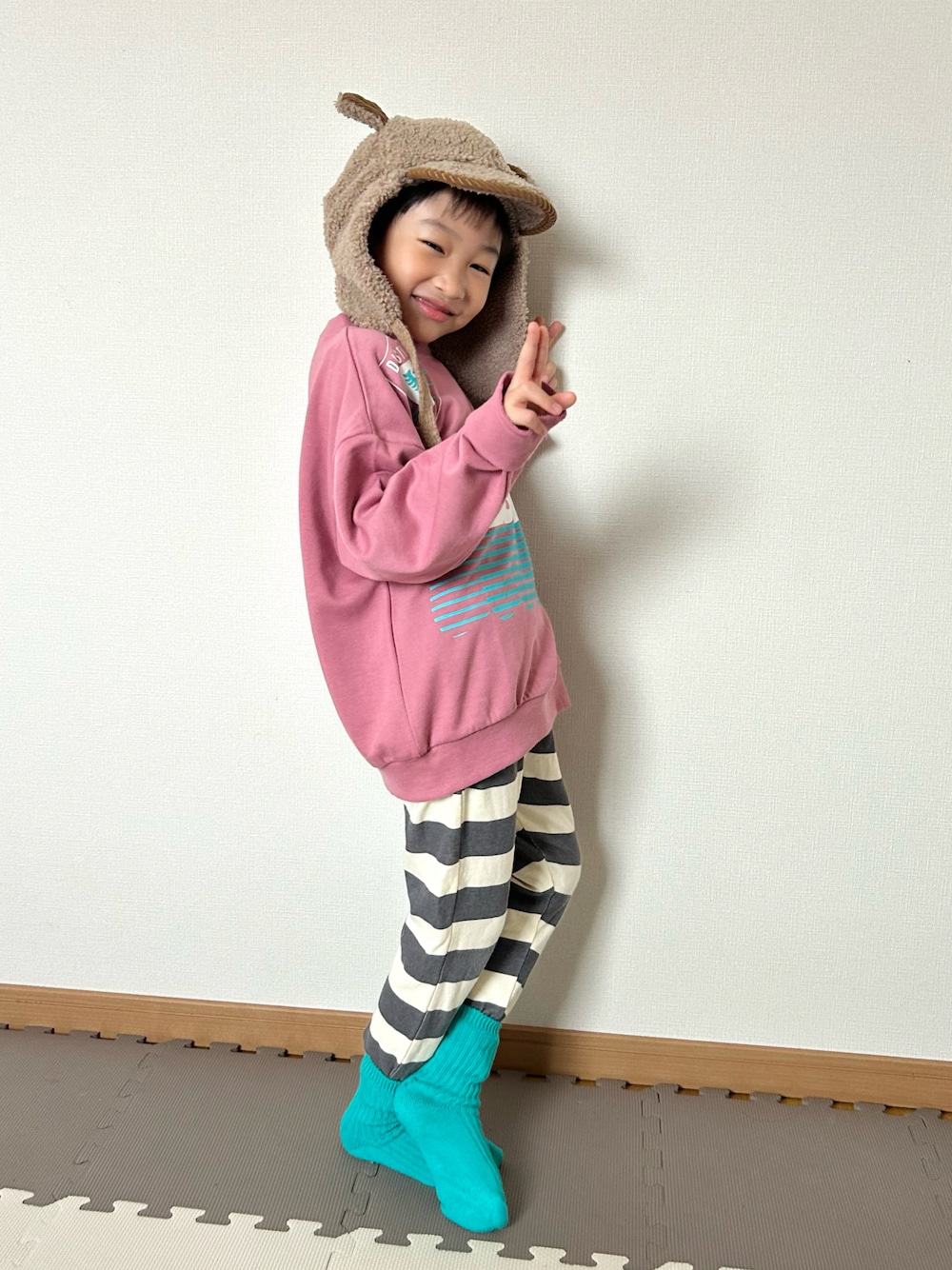 ピンク系のスウェット、グレー系のその他パンツ、グリーン系のソックス/靴下を着用したキッズの秋コーディネートの1枚目の写真