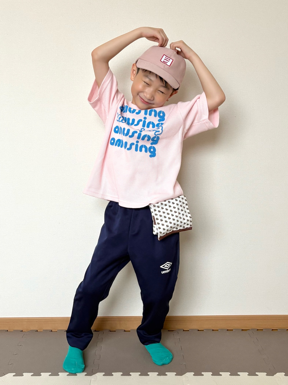 ピンク系のTシャツ/カットソー、ブルー系のジャージ、ブラウン系のポーチを着用したキッズの春コーディネートの1枚目の写真
