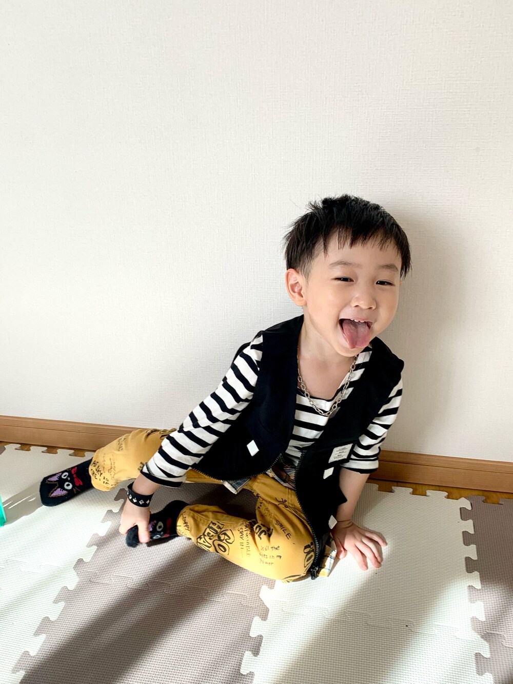ブラック系のベスト、ホワイト系のTシャツ/カットソー、イエロー系のその他パンツを着用したキッズの春コーディネートの1枚目の写真