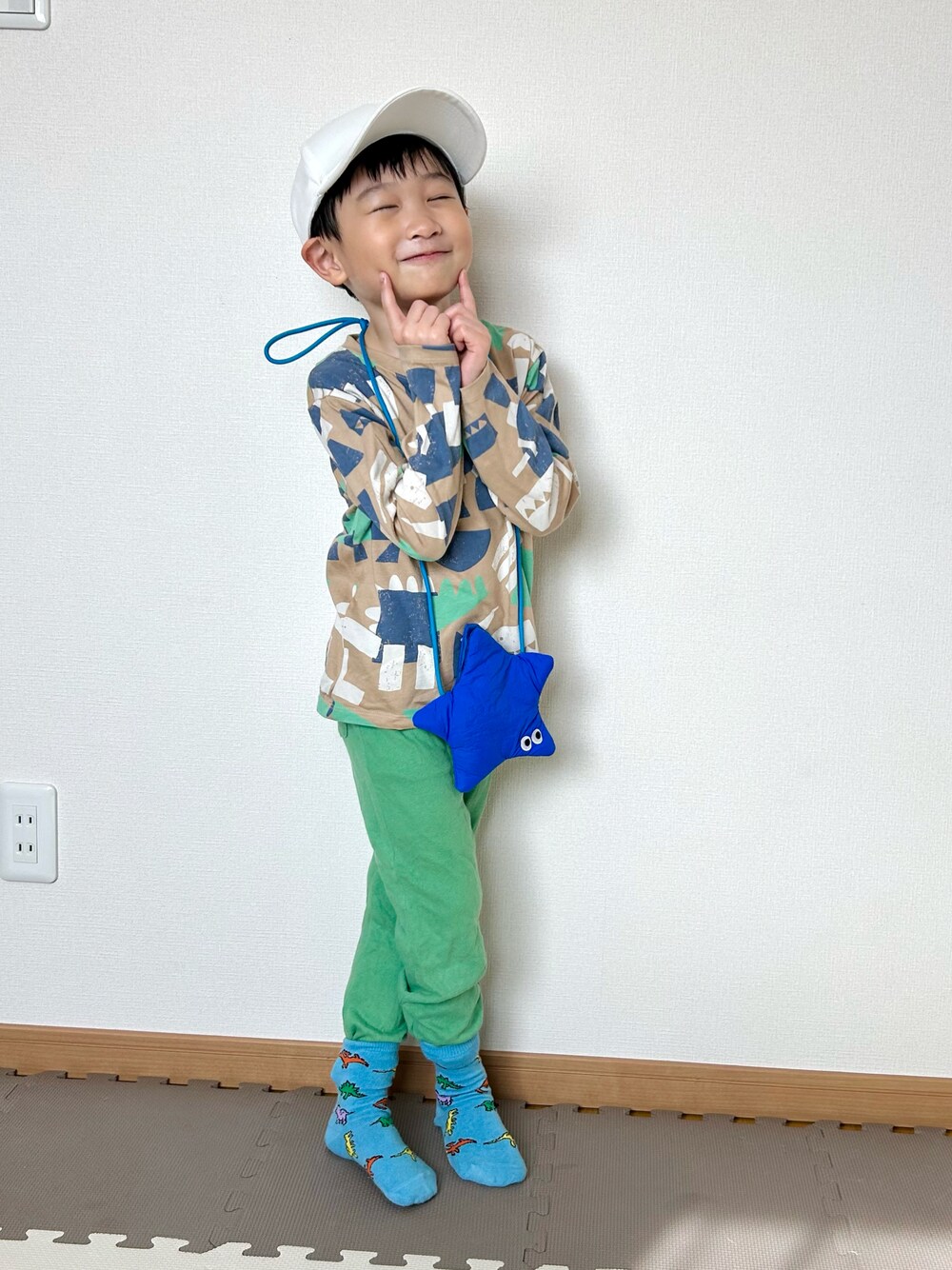 ベージュ系のTシャツ/カットソー、グリーン系のスウェットパンツ、ブルー系のショルダーバッグを着用したキッズの春コーディネートの1枚目の写真