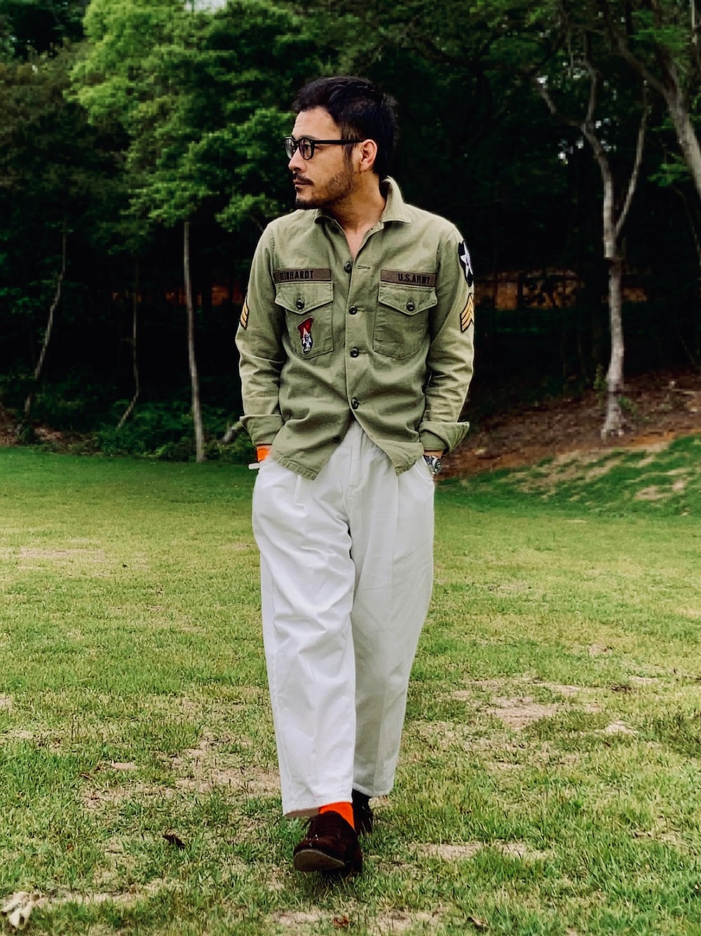 グリーン系のシャツ/ブラウス、ホワイト系のスラックス、ブラウン系のドレスシューズを着用したメンズの春コーディネートの1枚目の写真