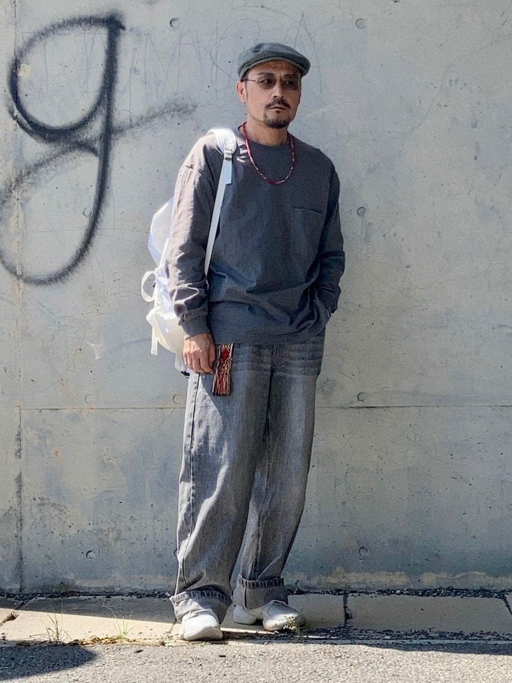 グレー系のTシャツ/カットソー、グレー系のデニムパンツ、グレー系のスニーカーを着用したメンズの秋コーディネートの1枚目の写真