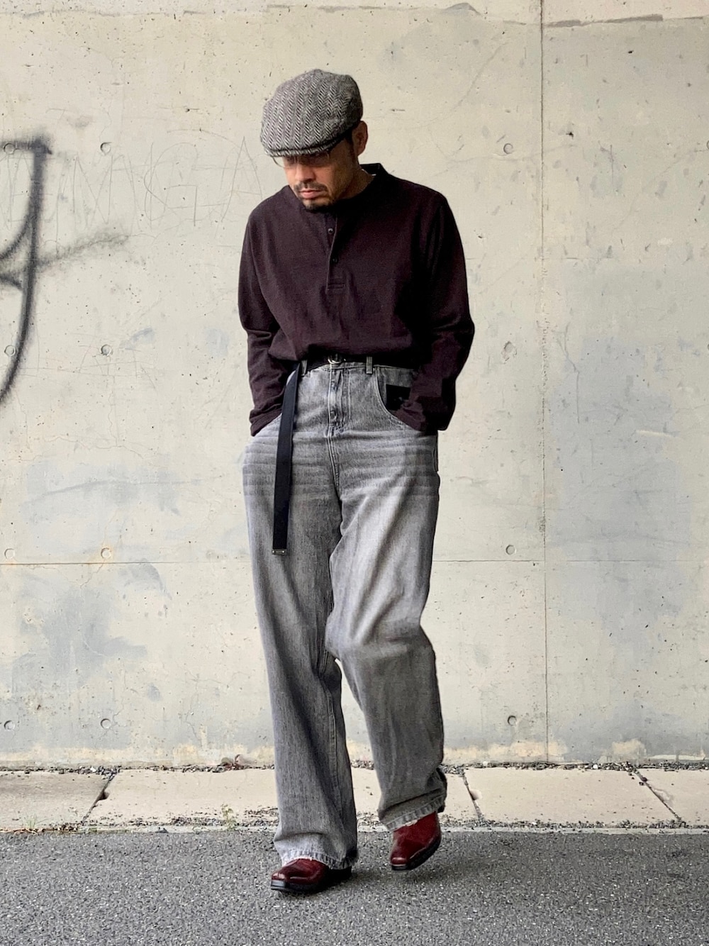 ブラウン系のTシャツ/カットソー、グレー系のデニムパンツ、レッド系のブーツを着用したメンズの秋コーディネートの1枚目の写真