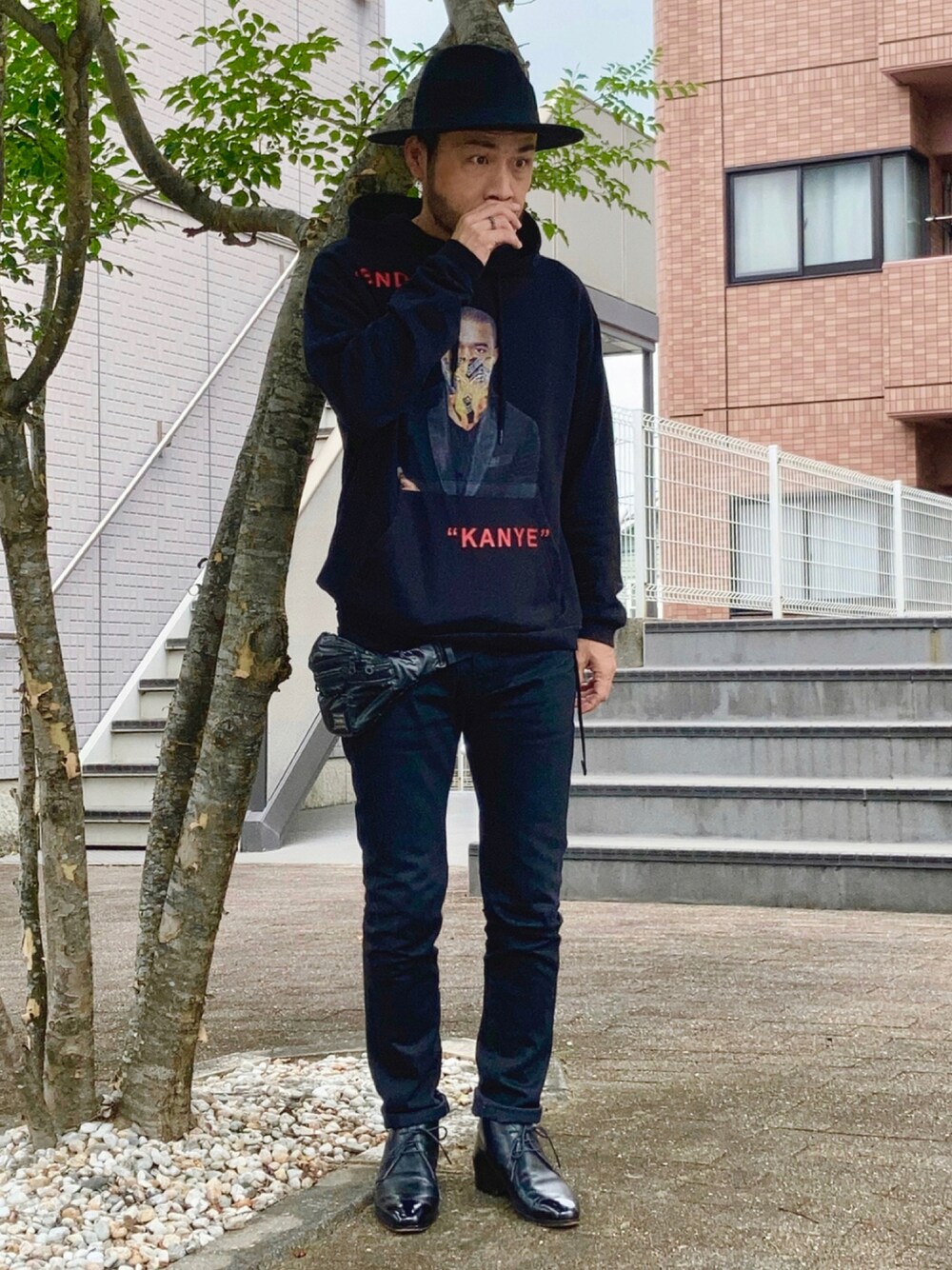 ブラック系のパーカー、ブラック系のデニムパンツ、ブラック系のブーツを着用したメンズの秋コーディネートの1枚目の写真