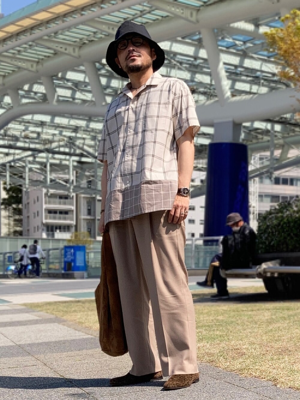 ベージュ系のシャツ/ブラウス、ベージュ系のスラックス、ブラウン系のスリッポンを着用したメンズの春コーディネートの1枚目の写真