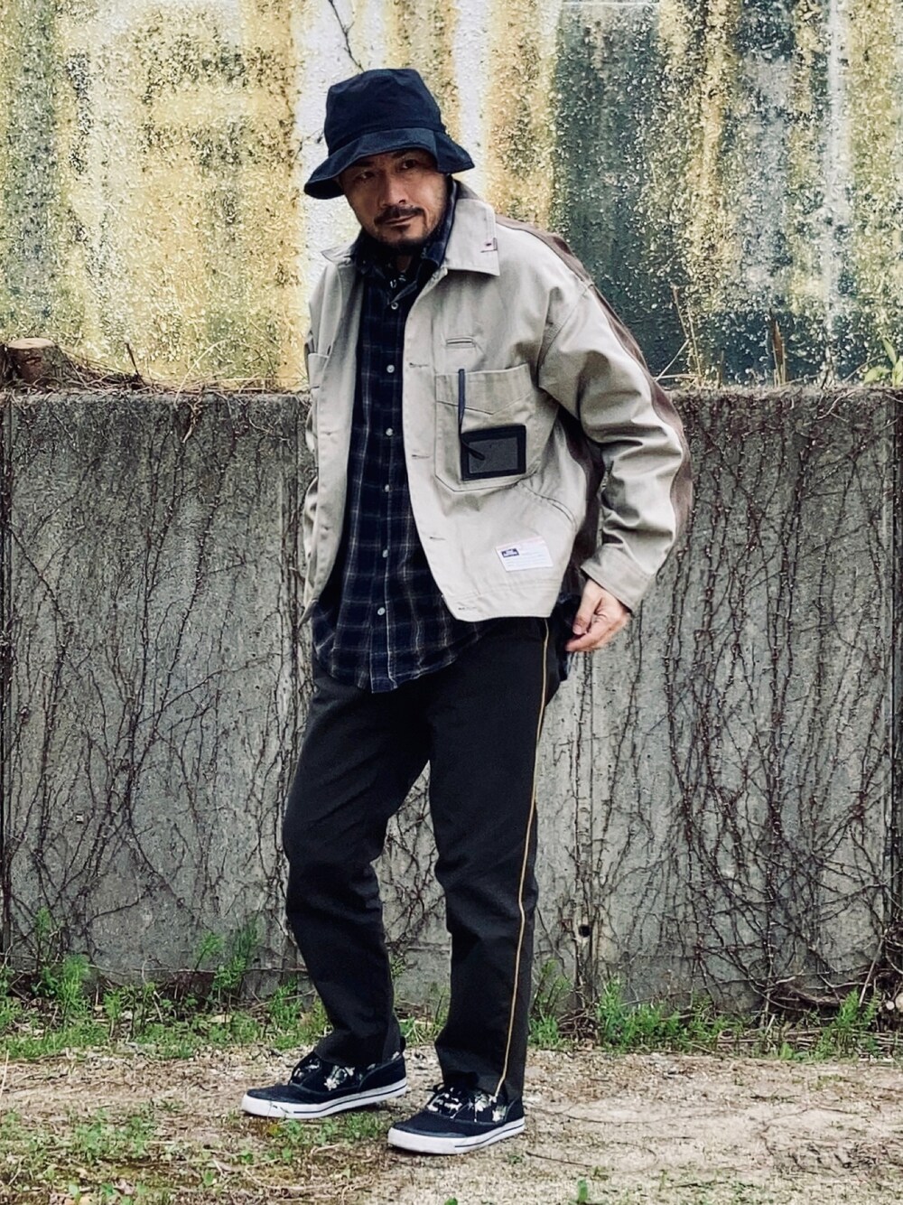 グレー系のシャツ/ブラウス、ベージュ系のその他アウター、グリーン系のスラックスを着用したメンズの春コーディネートの1枚目の写真