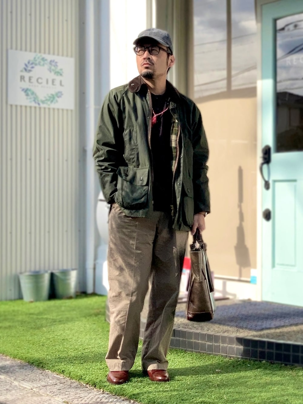 ブラウン系のTシャツ/カットソー、グリーン系のその他アウター、ベージュ系のチノパンツを着用したメンズの冬コーディネートの1枚目の写真