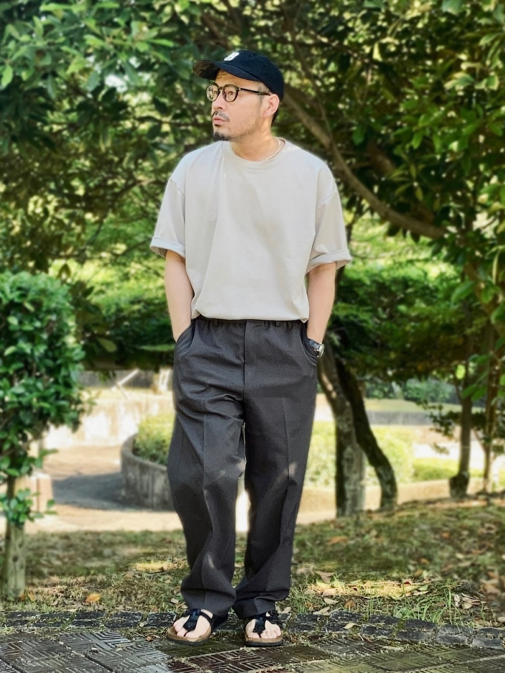 グレー系のTシャツ/カットソー、ブルー系のその他パンツ、ブラック系のサンダルを着用したメンズの夏コーディネートの1枚目の写真