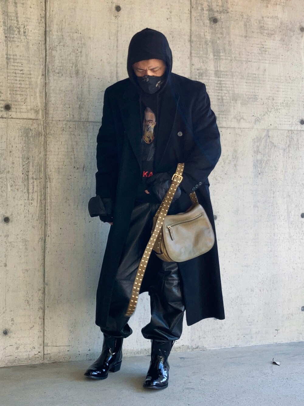 ブラック系のパーカー、ブラック系のチェスターコート、ブラック系のその他パンツを着用したメンズの冬コーディネートの1枚目の写真